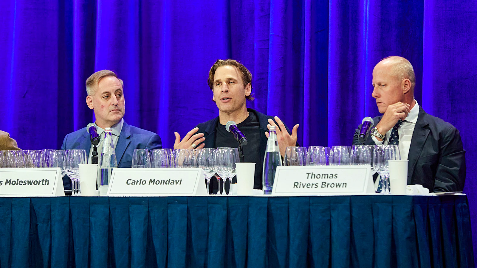 Carlo Mondavi speaking at a panel table next to James Molesworth (far left) and Thomas Rivers Brown (right)